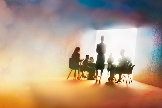 creative silhouette of a shadowed boardroom with a speaker and people sitting in front of them